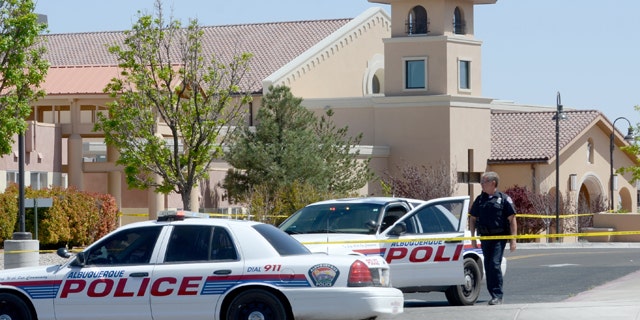 April 28, 2013: An Albuquerque Police officer walks behind the tape at St. Jude Thaddeus Catholic Church.
