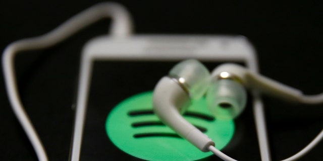 Earphones are seen on top of a smart phone with a Spotify logo on it, in Zenica February 20, 2014. Online music streaming service Spotify is recruiting a U.S. financial reporting specialist, adding to speculation that the Swedish start-up is preparing for a share listing, which one banker said could value the firm at as much as $8 billion (4 billion pounds). REUTERS/Dado Ruvic (BOSNIA AND HERZEGOVINA - Tags: SCIENCE TECHNOLOGY BUSINESS SOCIETY) - RTX1971J
