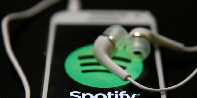 Earphones are seen on top of a smart phone with a Spotify logo on it, in Zenica February 20, 2014. Online music streaming service Spotify is recruiting a U.S. financial reporting specialist, adding to speculation that the Swedish start-up is preparing for a share listing, which one banker said could value the firm at as much as $8 billion (4 billion pounds). REUTERS/Dado Ruvic (BOSNIA AND HERZEGOVINA - Tags: SCIENCE TECHNOLOGY BUSINESS SOCIETY) - RTX1971J