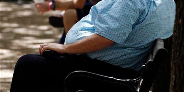 A heavyset man rests on a bench in Jackson, Miss., Sept. 4, 2014.