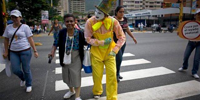 A mime helps a woman cross a street in Caracas, Venezuela. A new study shows small acts of kindness can improve our mental wellbeing and help us deal with stress.