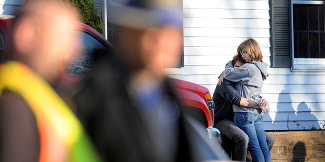 People embrace at a firehouse staging area for family around near the scene of a shooting at the Sandy Hook Elementary School in Newtown, Conn., about 60 miles (96 kilometers) northeast of New York City, Friday, Dec. 14, 2012. An official with knowledge of Friday's shooting said 27 people were dead, including 18 children. (AP Photo/Jessica Hill)