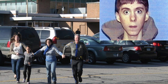 FILE - In this Friday, Dec. 14, 2012, file photo provided by the Newtown Bee, a police officer leads two women and a child from Sandy Hook Elementary School in Newtown, Conn., where a gunman opened fire, killing 26 people, including 20 children. A prosecutor is planning to release a report on the investigation into the massacre at Sandy Hook Elementary School on Monday, Nov. 25, 2013, but the public will have to wait longer for the Connecticut state policeâs full accounting of the crime.(AP Photo/Newtown Bee, Shannon Hicks, File) MANDATORY CREDIT: NEWTOWN BEE, SHANNON HICKS