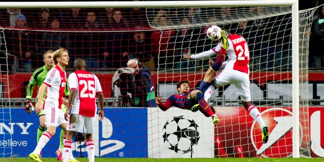 Barcelona's Neymar, second right, challenges Ajax's Stefano Denswil, first right, during the Group H Champions League soccer match between Ajax and FC Barcelona at the ArenA stadium in Amsterdam, Netherlands, Tuesday Nov. 26, 2013. (AP Photo/Patrick Post)