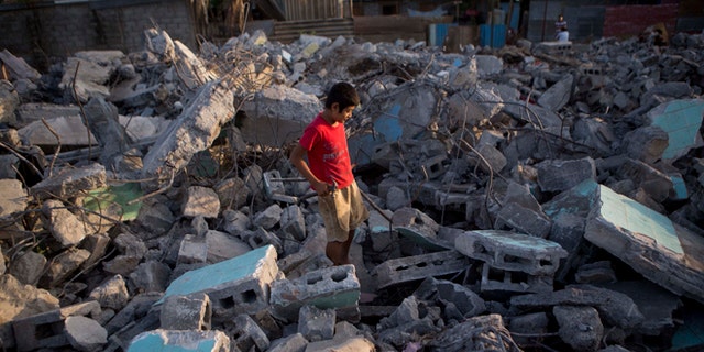 A boy searches for metal to sell, in the rubble of a building that was damaged in a 1972 earthquake and demolished after several recent earthquakes in Managua, Nicaragua, Monday, April 14, 2014. People who had been living in earthquake damaged buildings were ordered to evacuate after several quakes have affected Nicaragua since Thursday. (AP Photo/Esteban Felix)