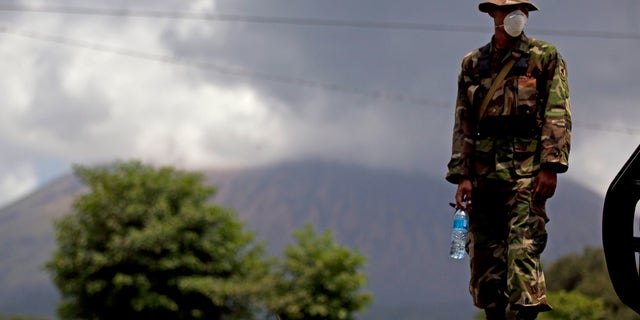 Sept. 8, 2012: A Nicaraguan soldier wears a protective mask as the San Cristobal volcano, in background, spews smoke and ash, near Chinandega, Nicaragua.