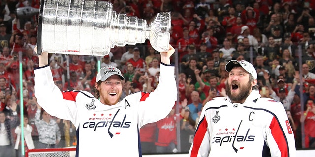 Alex Ovechkin #8 hands of the Stanley Cup to Nicklas Backstrom #19 of the Washington Capitals after their team's 4-3 win over the the Vegas Golden Knights in Game Five of the 2018 NHL Stanley Cup Final at T-Mobile Arena on June 7, 2018 in Las Vegas, Nevada. (Photo by Bruce Bennett/Getty Images)