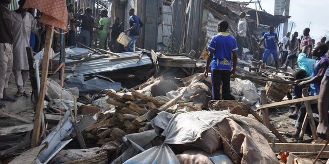July 1, 2014 - People gather at the scene of a car bomb explosion, at the central market, in Maiduguri, Nigeria. Many blamed Boko Haram, the Islamic extremist group whose birthplace is Maiduguri and which is accused of a series of recent bomb attacks in the West African nation.