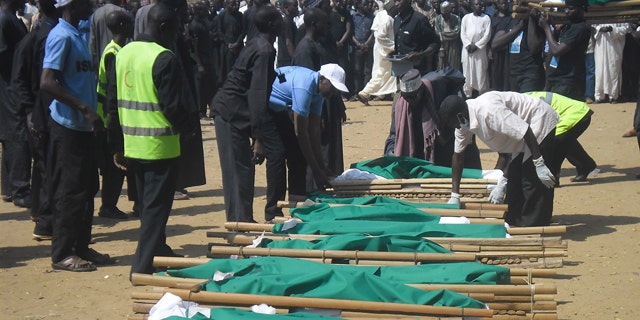 November 4, 2014: People prepare bodies of victims of a suicide bomb explosion for funeral in Potiskum, Nigeria. (AP Photo/Adamu Adamu)