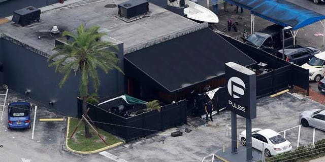 Law enforcement officials work at the Pulse Orlando nightclub following a fatal shooting Sunday, June 12, 2016, in Orlando, Fla. . (AP Photo/Chris O'Meara)