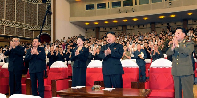 In this photo released by the Korean Central News Agency (KCNA) and distributed in Tokyo by the Korea News Service on Monday, July 9, 2012, North Korean leader Kim Jong Un, center right, and a woman clap with others as they watch performance by North Korea's new Moranbong band in Pyongyang, North Korea, Friday, July 6, 2012. The source did not identify the woman but South Korean media speculated that she could be Kims younger sister or wife. (AP Photo/Korean Central News Agency via Korea News Service) JAPAN OUT UNTIL 14 DAYS AFTER THE DAY OF TRANSMISSION