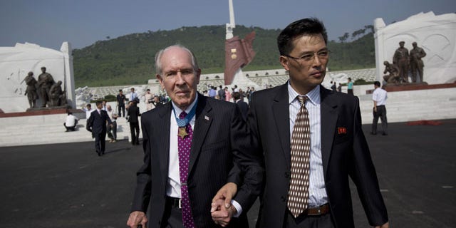 July 25, 2013: Retired U.S. Navy captain and Korean War veteran Thomas Hudner, left, is escorted by a North Korean official as he leaves a cemetery for Korean War veterans after a ceremony marking the 60th anniversary of the signing of the armistice that ended hostilities on the Korean peninsula. (AP PHOTO)