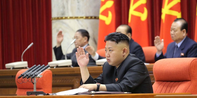 March 31, 2013: North Korean leader Kim Jong Un with other officials adopts a statement during a plenary meeting of the central committee of the ruling Workers' Party in Pyongyang, North Korea.
