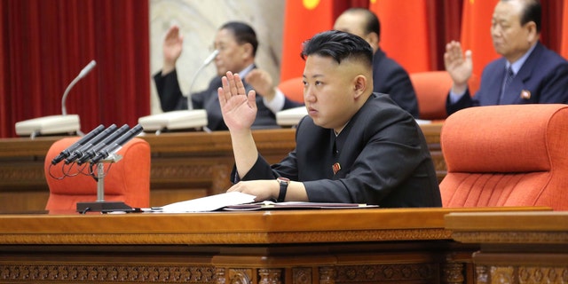 March 31, 2013: North Korean leader Kim Jong Un with other officials adopts a statement during a plenary meeting of the central committee of the ruling Workers' Party in Pyongyang, North Korea.