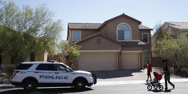 Sheldon Jacobs and his wife Nicole Jacobs walk in front of a home on the 6100 block of Stibor Street in North Las Vegas on Tuesday, April 1, 2014. Police in North Las Vegas think a family member may be responsible for a double-slaying at this home where officers sent to check on a missing 53-year-old mother and her 33-year-old daughter found a bloody crime scene. (AP Photo/Las Vegas Review-Journal, Justin Yurkanin) LOCAL TV OUT; LOCAL INTERNET OUT; LAS VEGAS SUN OUT