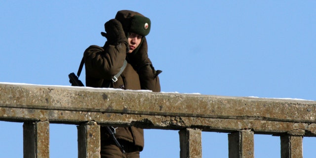 A North Korean soldier covers his ears after snowfall Dec. 17, 2014.