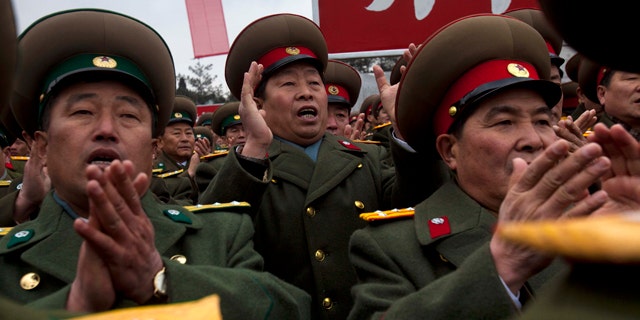 Feb.14,2012- North Korean military members cheer during the unveiling of a new bronze statue depicting the late leader Kim Jong Il and his father Kim Il Sung at Mansudae Art Studio in Pyongyang. As North Koreans prepare for what would have been the 70th birthday of late leader Kim Jong Il this week, the country's state media have gone to great lengths to build up the man who led the nation for 17 years until his death in December.