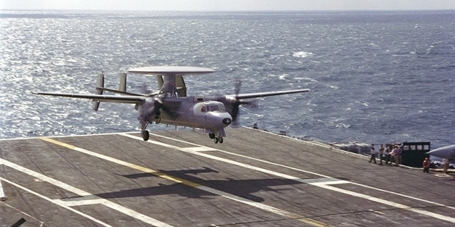 A Northrop Grumman E-2C Hawkeye 2000 surveillance and reconnaisance plane lands on a carrier.