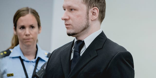 May 10, 2012: Anders Behring Breivik, who has admitted to the July 22, 2011 massacre and a bombing in Oslo that killed eight people earlier that day, stands with a police woman in court in Oslo.