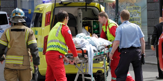 May 15, 2012: A man who set fire to himself outside the courthouse in Oslo where the trial of Anders Behring Breivik is taking place, is taken into an ambulance.