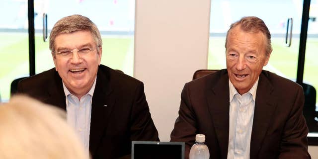 FILE - In this Monday May 19, 2014 fie photo, International Olympic Committee President Thomas Bach. left, smiles  as he sits with Norwegian IOC-member Gerhard Heiberg  during a meeting Norway's Minister of Culture, Thorhild Widvey in Oslo. Oslo said it is dropped its bid for the 2022 Winter Olympics after the Norwegian government declined Wednesday, Oct. 1, 2014 to provide financial backing, a move which leaves just two cities in a race that has been decimated by withdrawals. (AP Photo: Hakon Mosvold Larsen / NTB scanpix, File) NORWAY OUT
