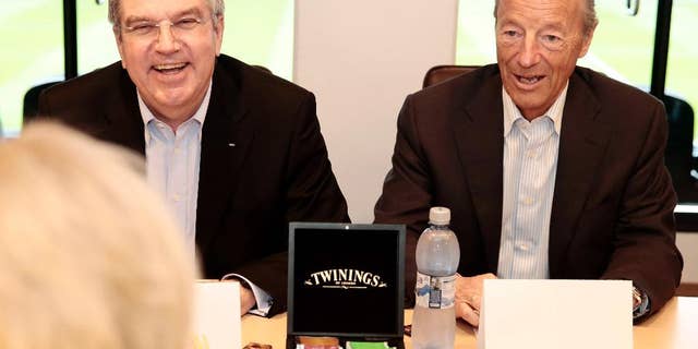 FILE - In this Monday May 19, 2014 fie photo, International Olympic Committee President Thomas Bach. left, smiles as he sits with Norwegian IOC-member Gerhard Heiberg during a meeting Norway's Minister of Culture, Thorhild Widvey in Oslo. Oslo said it is dropped its bid for the 2022 Winter Olympics after the Norwegian government declined Wednesday, Oct. 1, 2014 to provide financial backing, a move which leaves just two cities in a race that has been decimated by withdrawals. (AP Photo: Hakon Mosvold Larsen / NTB scanpix, File) NORWAY OUT