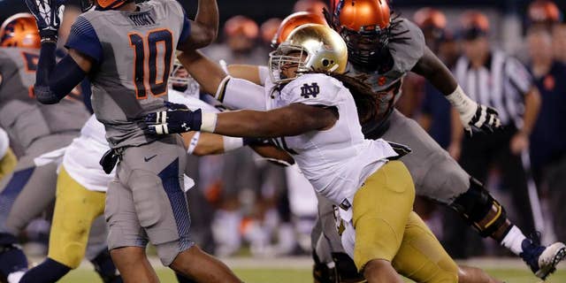 Notre Dame defensive lineman Sheldon Day, right, applies pressure on Syracuse quarterback Terrel Hunt (10) during the second half of an NCAA college football game, Saturday, Sept. 27, 2014, in East Rutherford, N.J. Notre Dame won 31-15. (AP Photo/Julio Cortez)