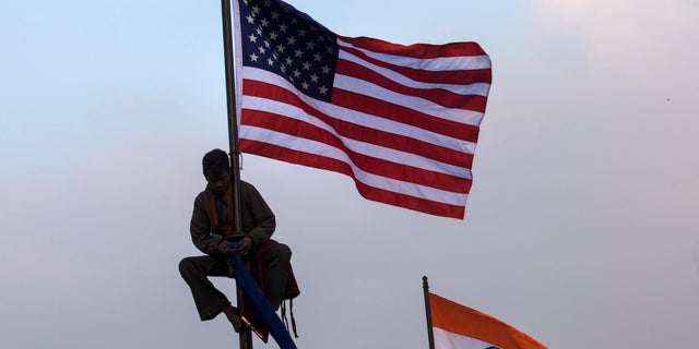 Jan. 23, 2015: An Indian worker places an American flag on a flag pole in New Delhi, India.