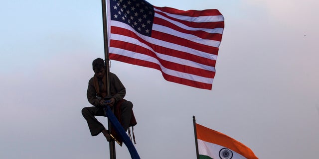 Jan. 23, 2015: An Indian worker places an American flag on a flag pole in New Delhi, India.