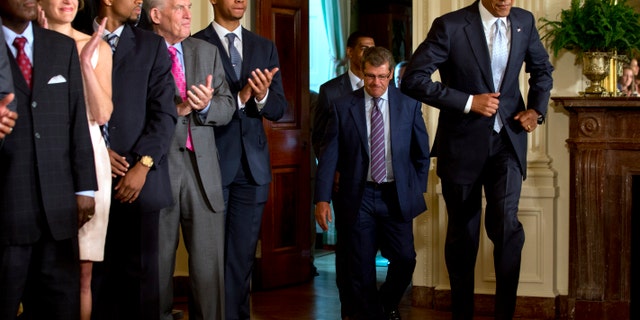 June 9, 2014: President Barack Obama jogging in to an event honoring the NCAA Basketball Champion UConn Huskies Men's and Women's Basketball teams, and their 2014 NCAA Championships in the East Room of the White House in Washington.