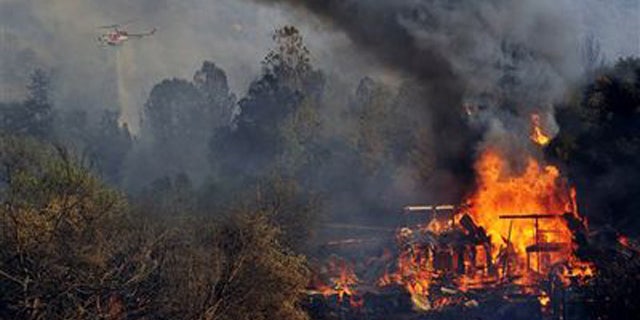 File -- August 18, 2014: A structure burns along Highway 41 in Oakhurst, Calif. (AP Photo/The Fresno Bee, Eric Paul Zamora)