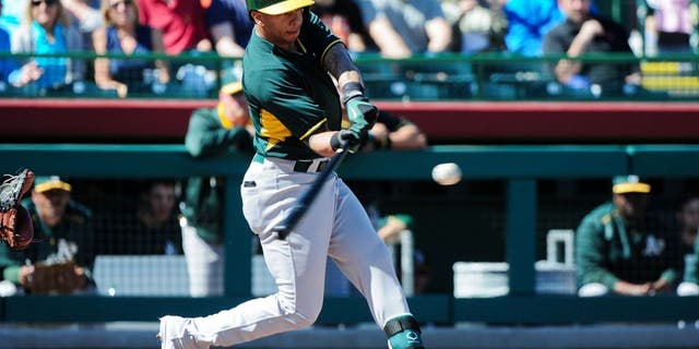 Mar 4, 2015; Scottsdale, AZ, USA; Oakland Athletics second baseman Tyler Ladendorf (25) flies out during the first inning against the San Francisco Giants during a spring training baseball game at Scottsdale Stadium. Mandatory Credit: Matt Kartozian-USA TODAY Sports