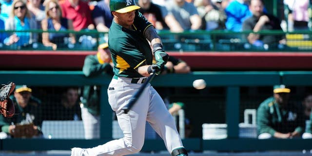 Mar 4, 2015; Scottsdale, AZ, USA; Oakland Athletics second baseman Tyler Ladendorf (25) flies out during the first inning against the San Francisco Giants during a spring training baseball game at Scottsdale Stadium. Mandatory Credit: Matt Kartozian-USA TODAY Sports