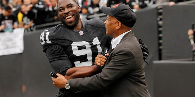 Dec 7, 2014; Oakland, CA, USA; Oakland Raiders defensive end Justin Tuck (91) meets with former NFL player Ronnie Lott before the start of the game against the San Francisco 49ers at O.co Coliseum. Mandatory Credit: Cary Edmondson-USA TODAY Sports
