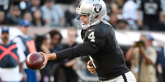 August 14, 2015; Oakland, CA, USA; Oakland Raiders quarterback Derek Carr (4) hands the football off against the St. Louis Rams during the first quarter in a preseason NFL football game at O.co Coliseum. Mandatory Credit: Kyle Terada-USA TODAY Sports
