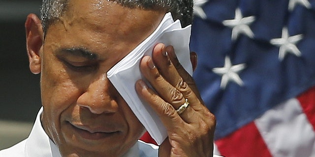 FILE -- June 25, 2013: President Obama wipes his face as he speaks about climate change, Tuesday, June 25, 2013, at Georgetown University in Washington.