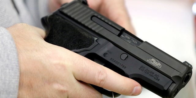 David Foley holds a handgun while shopping at the Spring Guns and Ammo store Monday, Jan. 4, 2016, in Spring, Texas. President Barack Obama is making good on his pledge to politicize gun violence. The package of gun-control executive actions Obama will formally announce Tuesday has pushed the contentious issue to the forefront of the 2016 presidential campaign, just weeks from the Feb. 1 Iowa caucuses.(AP Photo/David J. Phillip)