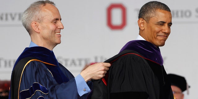 COLUMBUS, OH - MAY 05:  Ohio State Trustee David Horn (L) puts a sash on U.S. President Barack Obama during commencement ceremonies at The Ohio State University at Ohio Stadium on May 5, 2013 in Columbus, Ohio. Obama addressed the graduates a year from the day he kicked off his re-election campaign at the campus.The president was also given an honorary degree Doctor of Laws. (Photo by Matt Sullivan/Getty Images)