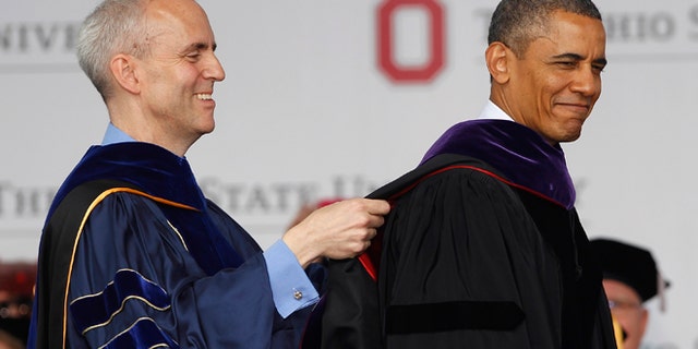 COLUMBUS, OH - MAY 05: Ohio State Trustee David Horn (L) puts a sash on U.S. President Barack Obama during commencement ceremonies at The Ohio State University at Ohio Stadium on May 5, 2013 in Columbus, Ohio. Obama addressed the graduates a year from the day he kicked off his re-election campaign at the campus.The president was also given an honorary degree Doctor of Laws. (Photo by Matt Sullivan/Getty Images)