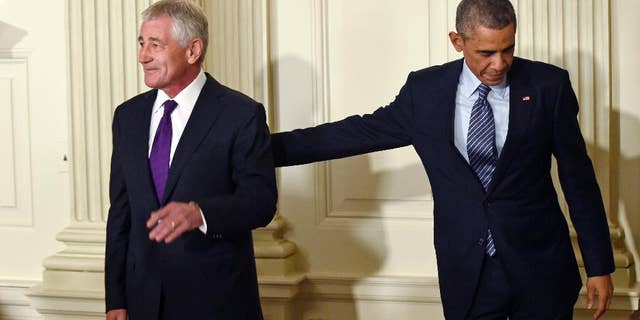 President Barack Obama, left, reaches over to touch Defense Secretary Chuck Hagel, left, following an announcement of Hagel's resignation during an event in the State Dining Room of the White House in Washington, Monday, Nov. 24, 2014. Hagel is stepping down under pressure from Obama's Cabinet, senior administration officials said Monday, following a tenure in which he has struggled to break through the White House's insular foreign policy team. (AP Photo/Susan Walsh)