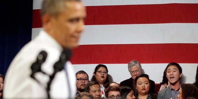 In this Nov. 25, 2013, photo, President Barack Obama, left, stops his speech and turns around in response to an unidentified man, right, who heckled him about anti-deportation policies, at the Betty Ann Ong Chinese Recreation Center in San Francisco. Obama stopped his speech about immigration reform to let this man, who was located directly behind Obama, speak and would respond to his questions. Advocates are frustrated with the failure of House Republicans to tackle immigration. Increasingly, theyâre focus is on President Barack Obama. The outside groups are demanding that Obama use his powers as chief executive to stop deportations or provide some relief to many of the 11 million immigrants living here illegally. (AP Photo/Pablo Martinez Monsivais, File)
