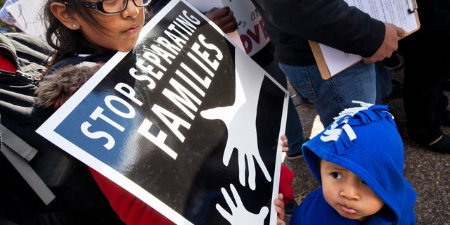 US citizens Esmeralda Tepetate, 10, with her brother Sebastian, 2, whose parents are originally from Mexico, holds a sign that says "stop separating families" during a rally for comprehensive immigration reform, Friday, Nov. 7, 2014, outside of the White House in Washington. After the midterm elections immigration groups are pushing for executive action. (AP Photo/Jacquelyn Martin)