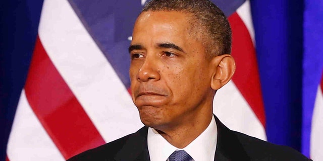 President Barack Obama pauses while speaking about National Security Agency (NSA)surveillance, Friday, Jan. 17, 2014, at the Justice Department in Washington. Seeking to calm a furor over U.S. surveillance, the president called for ending the government's control of phone data from hundreds of millions of Americans and immediately ordered intelligence agencies to get a secretive court's permission before accessing the records. (AP Photo/Charles Dharapak)