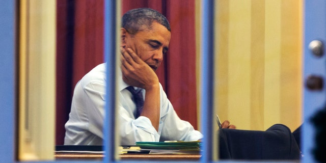 President Barack Obama works at his desk in the Oval Office of the White House in Washington, Monday, Jan. 27, 2014, ahead of Tuesday night's State of the Union speech. (AP Photo/Jacquelyn Martin)