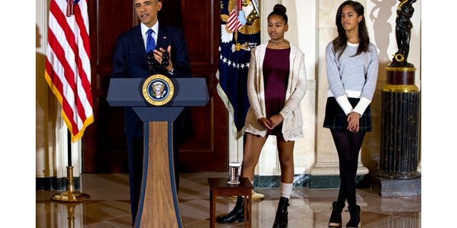 November 26, 2014: President Barack Obama, joined by his daughters Malia, right, and Sasha, center, speaks during the presidential turkey pardon ceremony at the White House. (AP Photo/Jacquelyn Martin)