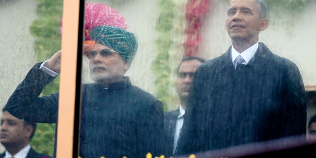 Jan. 26, 2015: Indian Prime Minister Narendra Modi, left, and U.S. President Barack Obama, right, look out through rain covered protective glass to watch the Republic Day Parade in New Delhi. (AP Photo/Carolyn Kaster)