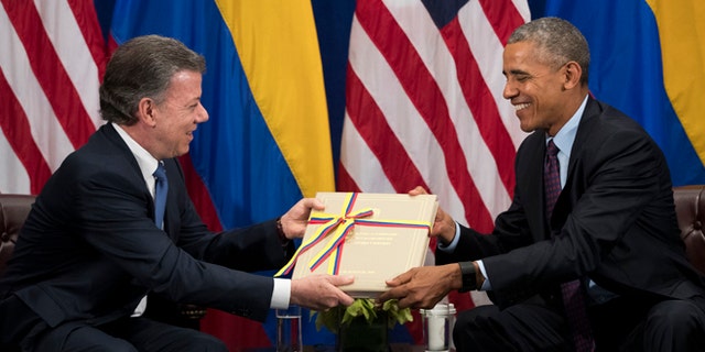 NEW YORK, NEW YORK - SEPTEMBER 21: (L to R) President of Colombia Juan Manuel Santos gives U.S. President Barack Obama a copy of the Colombian peace agreement during bilateral meeting at the Lotte New York Palace Hotel, September 21, 2016 in New York City. In Tuesday's speech to the United Nations General Assembly, Obama stated that 'helping Colombia end Latin America's longest war' was among his major accomplishments as president. Last month, the Colombian government reached a peace agreement with the Revolutionary Armed Forces of Colombia (FARC). (Photo by Drew Angerer/Getty Images)