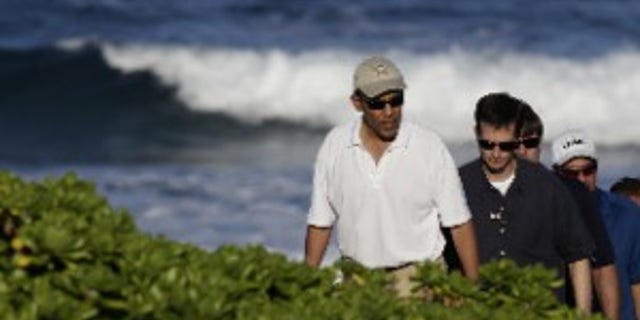 President Barack Obama, left, walks on Pyramid Rock beach on Marine Corps Base Hawaii in Kaneohe Bay, Hawaii Saturday, Dec. 26, 2009. The Obamas are in Hawaii for the holidays.(AP Photo/Alex Brandon)
