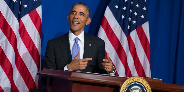 President Obama smiles after signing an executive order to improve security measures for government credit and debit cards.