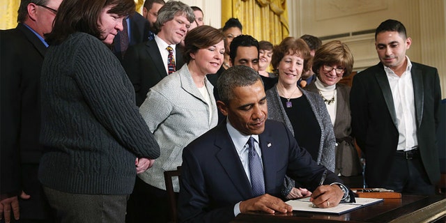 U.S. President Barack Obama jokes with guests before signing a presidential memorandum for modernizing overtime protections for workers during an event in the East Room of the White House, on March 13, 2014 in Washington, DC. The memorandum will direct the Secretary of Labor to begin the process of addressing overtime pay protections to make sure millions of workers are paid a fairly. (Photo by Mark Wilson/Getty Images)